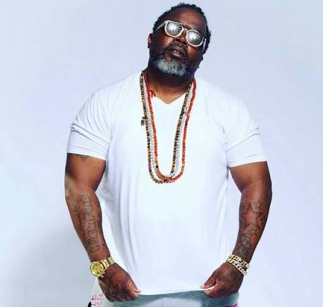 Tyranny Allen in a white T-shirt and beaded necklaces, wearing mirrored sunglasses